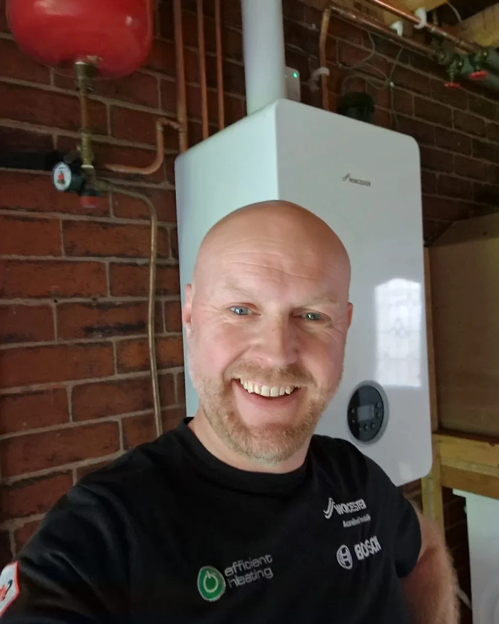 Lee Hartley, Gas-Safe registered engineer, in front of a Worcester boiler he installed in Leeds